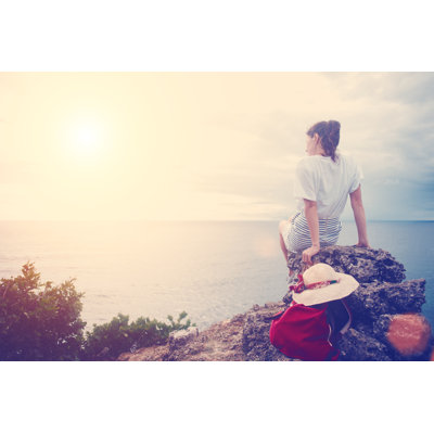 Young Woman with Hat and Backpack Sitting on a Cliff 1 Piece Wrapped Canvas Wall Art