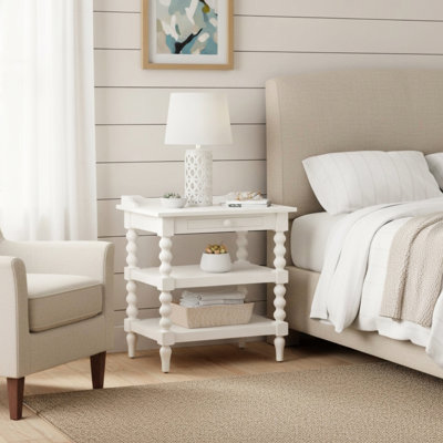 Table de chevet avec finition blanc antique, faite de bois franc massif et de placages de chêne, deux tablettes de rangement, un plateau coulissant, des pieds tournés à la bobine, une conception compacte du plateau supérieur sur le dos, un placage, une structure inférieure et une structure