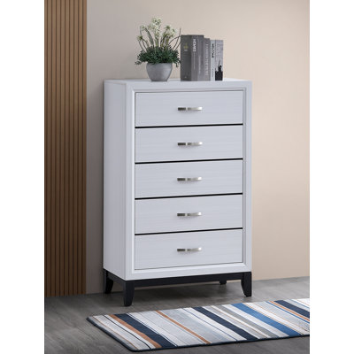 La commode et la commode avec une finition en bois et des poignées métalliques minces maximisent l'espace vertical pour le rangement dans la chambre à coucher moderne