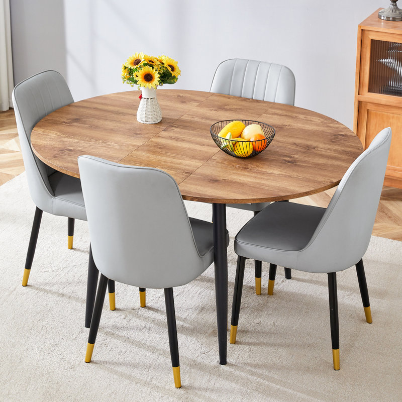 Ensemble de table et de chaises. Table de salle à manger moderne en bois aggloméré extensible. La table a une conception télescopique, adaptée aux rassemblements de différentes tailles.