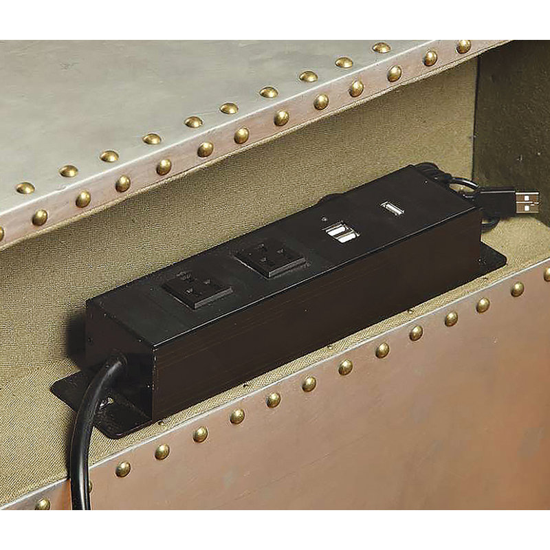 Table de chevet en aluminium Brancaster avec ports USB, avec garniture cloutée, compartiments ouverts et pieds de roulette pour un rangement pratique de style industriel.