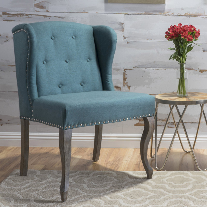 Fauteuil à oreilles classique bleu sarcelle avec pieds décoratifs et bordure cloutée