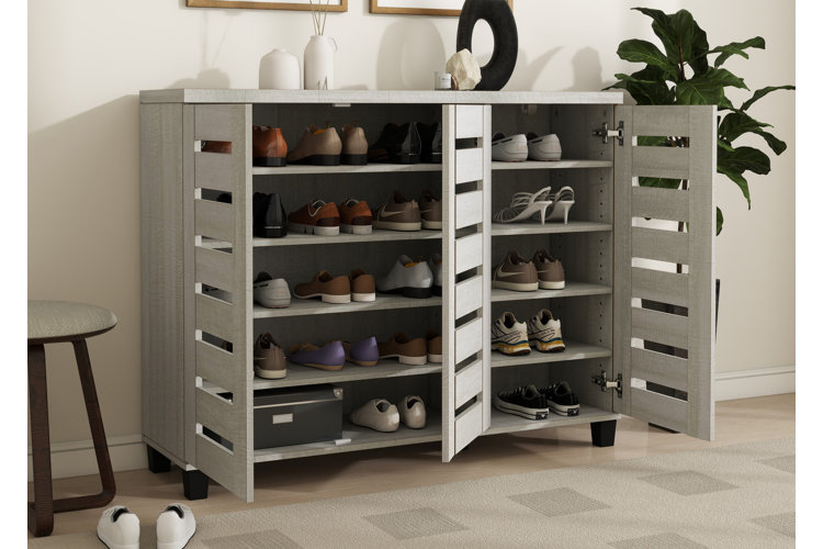 A gray shoe cabinet opened to reveal five shelves lined with pairs of shoes.