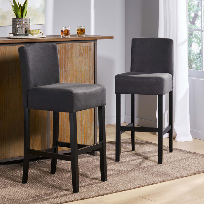 Élégant tabouret de bar avec pieds en bois d'hévéa, siège en tissu confortable et assemblage facile pour les cuisines et les bars modernes.