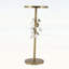 Luxueuse table d'appoint ronde en fer avec accents floraux dorés et blancs, base en ciment robuste pour une décoration intérieure élégante