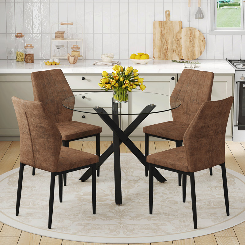 Ensemble table et chaises. Table ronde moderne en verre : 99 cm de diamètre, piètement en métal noir en forme de X. Accompagnée de 4 chaises de salle à manger marron et noires à motif coquillage. Alliant confort et style.