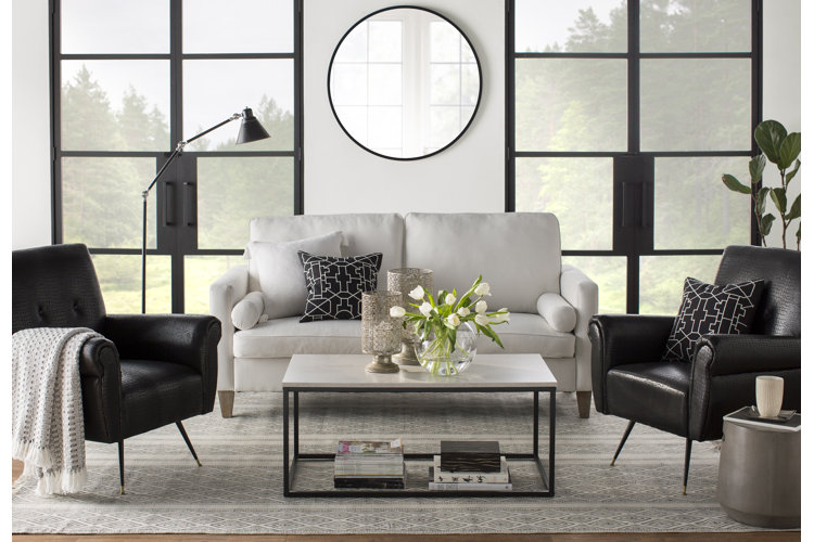 white leather sofa next to two leather chairs