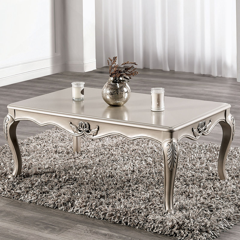 Table basse de style traditionnel avec pieds incurvés, conception sculptée, structure en bois massif et finition champagne élégante