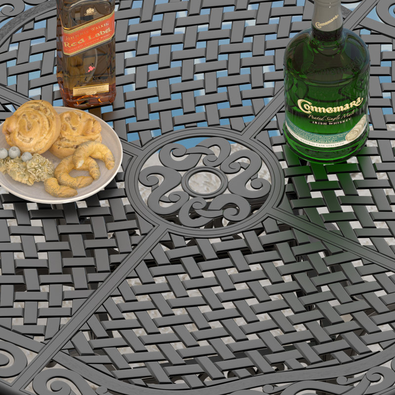 Ensemble de salle à manger d'extérieur rond en aluminium moulé de 5 pièces (122 cm) avec trou pour parasol, 4 chaises empilables et coussins bleus.