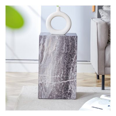 Rehaussez votre espace de vie avec cette table basse moderne en bois aggloméré, qui met en valeur des motifs texturés gris. Il est caractérisé par un design élégant.