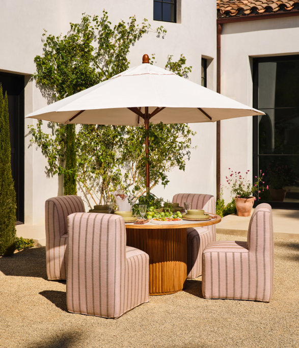 Outdoor dining set with an umbrella and striped chairs.