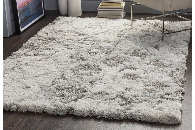 A white and gray marble-patterned shag rug.