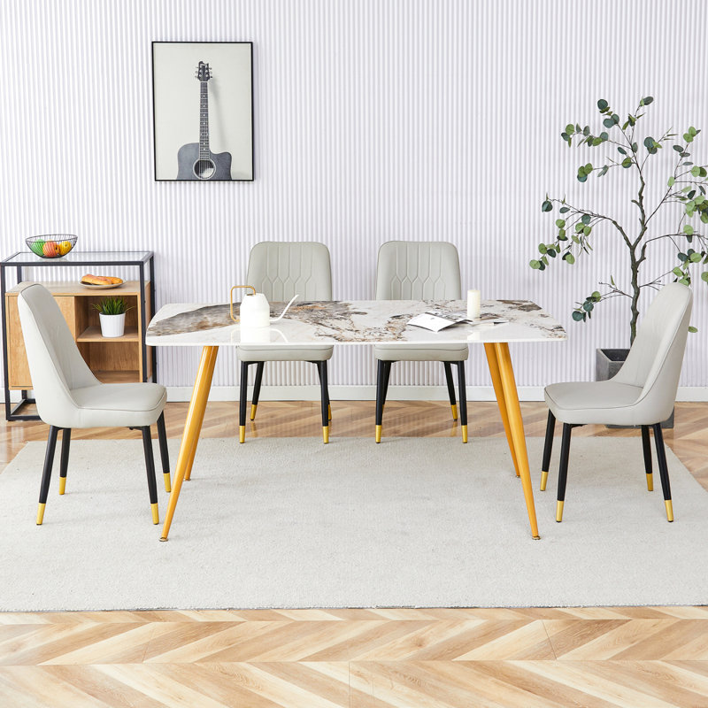 Ensemble de table et de chaises. Table de salle à manger moderne minimaliste.  Bureau imitation marbre à motif de pierres frittées avec pieds en métal doré et 4 chaises confortables avec sièges en polyuréthane et pieds en métal.