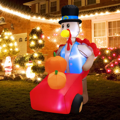 Dinde poussant un chariot de citrouille gonflable