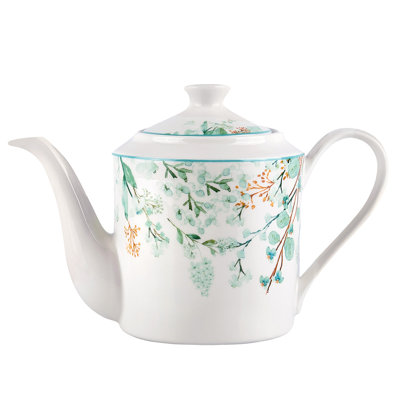 Théière en porcelaine et feuilles vertes