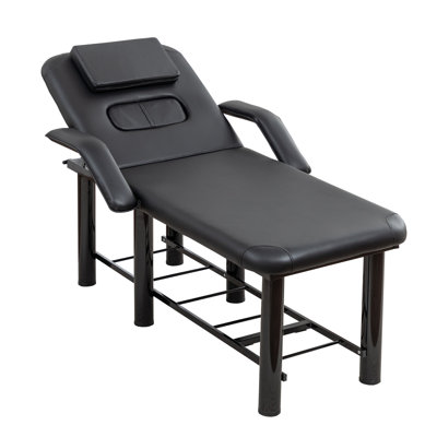 Lit de massage professionnel noir avec appui-tête et coussins pour les seins amovibles, accoudoirs et tablette de rangement pour les soins du visage et du corps.