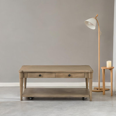Table basse rectangulaire en bois massif avec deux tiroirs et roulettes de rangement, design décontracté transitionnel au fini sable