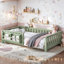 Sage green toddler floor bed with built-in side storage shelf and surrounding safety guardrails.