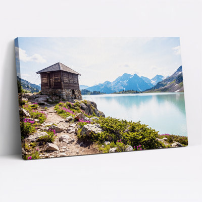 Tableau sur toile représentant un chalet alpin surplombant un lac turquoise et des montagnes