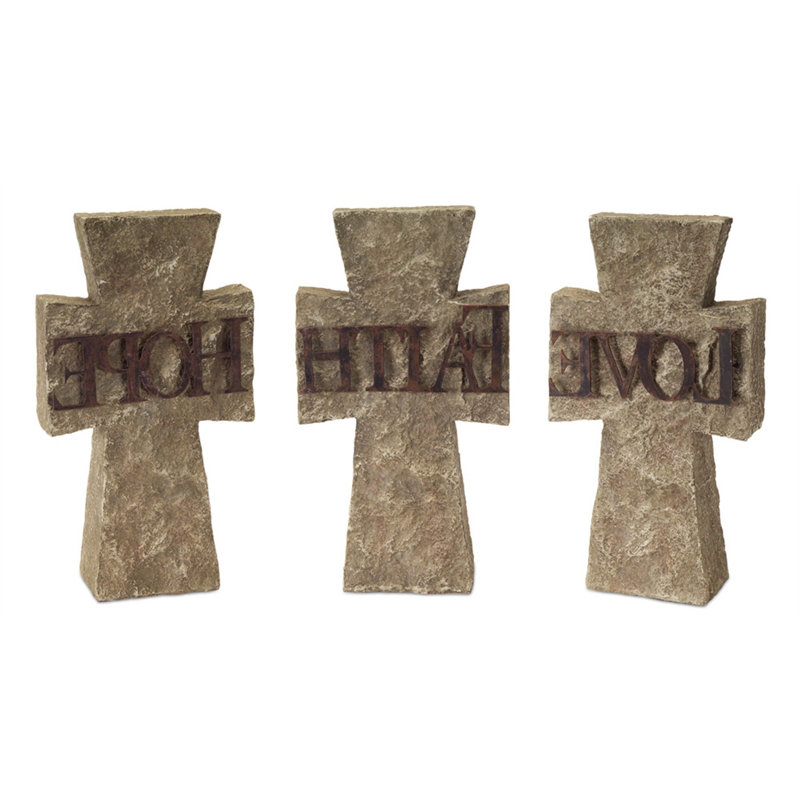 Ensemble de trois statues en forme de croix de ciment grise sur table