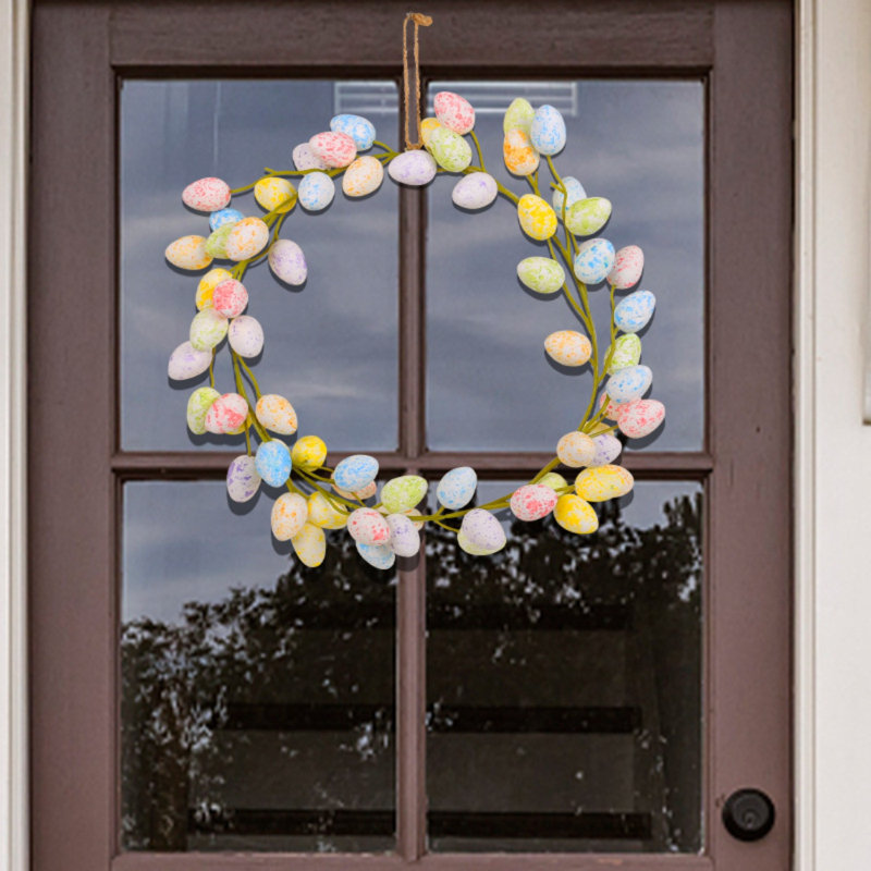 Couronne de fleurs de Pâques avec œufs colorés pour porte d'entrée