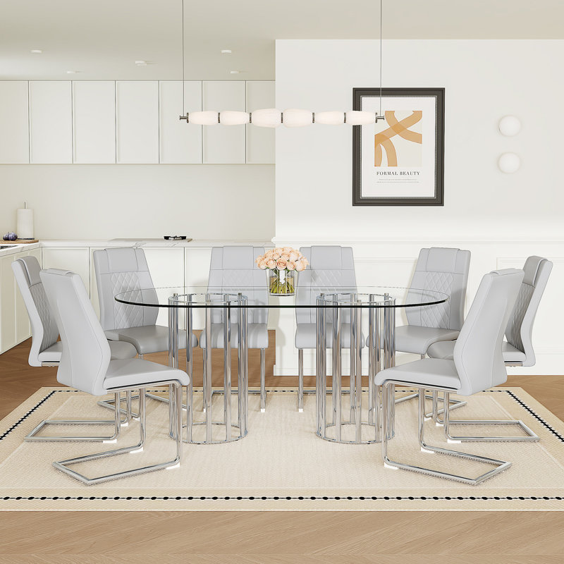 Ensemble de salle à manger 9 pièces, table ovale en verre trempé transparent de 180 cm, chaises à dossier haut en similicuir à motif quadrillé, piètement en métal argenté arqué, gris pâle