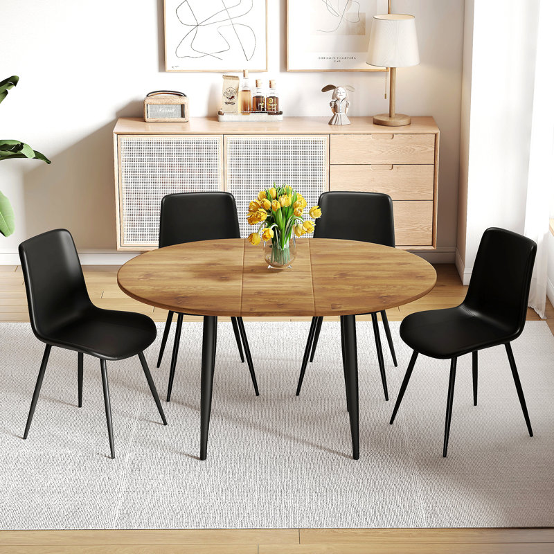 Ensemble de table et de chaises. Table de salle à manger moderne en MDF extensible. Convient pour des rassemblements de différentes tailles. Assorti de 4 chaises en polyuréthane artificielles noires avec coussins incurvés.