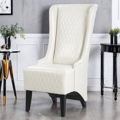 Fauteuil à oreilles haut dossier en velours avec coutures en losanges et pieds en bois de bouleau