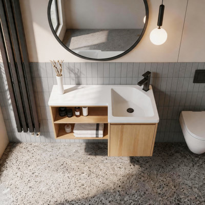 Meuble-lavabo d'angle flottant avec lavabo intégré en résine gélifiée, meuble-lavabo mural en L, finition chêne clair, porte à fermeture en douceur et tablettes ouvertes, meuble-lavabo moderne peu encombrant
