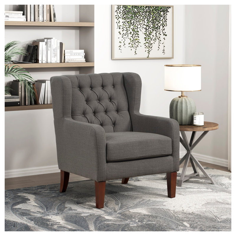 Fauteuil à oreilles classique avec dossier capitonné, revêtement gris foncé et pieds en bois massif