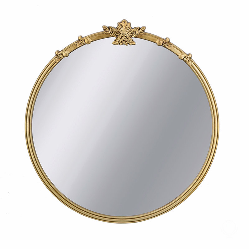 Miroir mural rond avec finition dorée et écusson décoratif