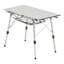 Table de pique-nique extérieure en aluminium argenté, pliable et à hauteur réglable, avec un plateau en maille de 90 cm de large, une structure en acier sans soudure pour une stabilité optimale, et un format compact et enroulable pour un rangement facile dans un garage.