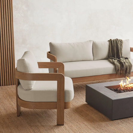 Outdoor seating area with sofa, chair, and fire pit.