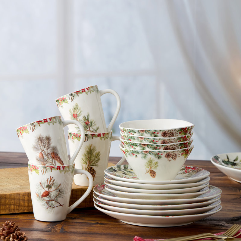 Service de table 16 pièces Woodland - Quatre couverts complets pour les fêtes avec des branches de pin, des pommes de pin et des baies rouge rubis sur un grès blanc lumineux.