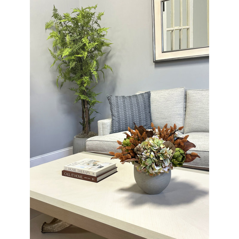 Centre de table d'automne avec hortensias, artichauts et pommes de pin