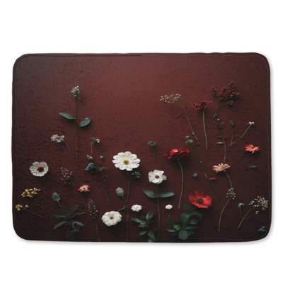 Assortiment de fleurs sauvages sur un tapis de bain rouge