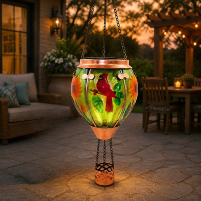 A waterproof glass hot-air-balloon solar hanging lantern creates a flame effect and Cardinal theme for lawns, porches, trees, or yards and can be given as a unique gift. For outdoor use.