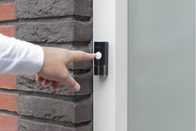 Black and white doorbell chime and finger pushing doorbell
