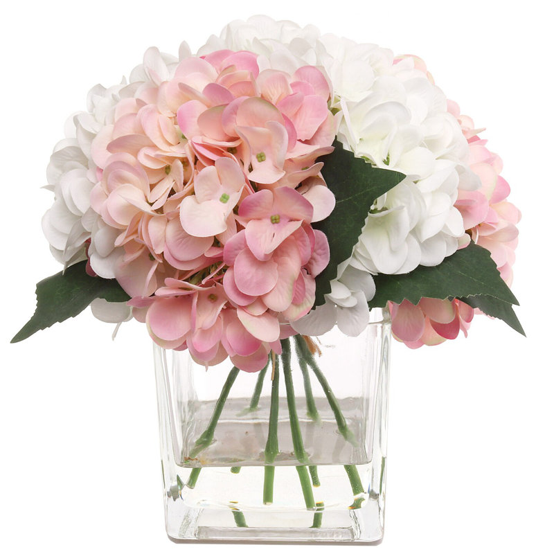 Hortensias roses et blanches dans un vase en verre avec de l'eau