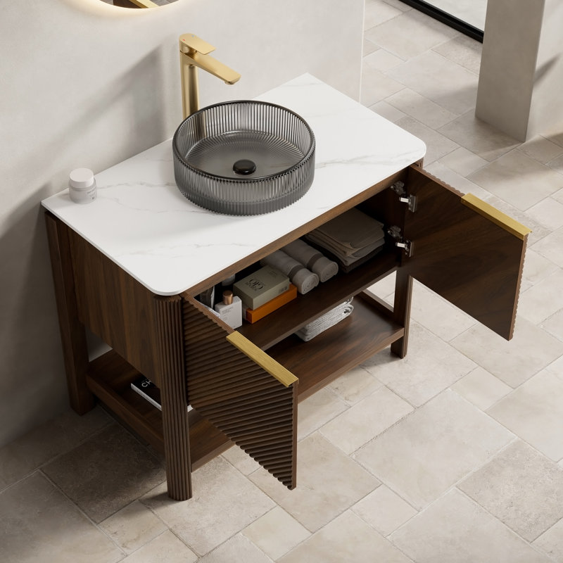 Meuble-lavabo autoportant avec comptoir en pierre frittée, vasque, armoire en contreplaqué, portes cannelées en diagonale, tablette ouverte et quincaillerie à fermeture en douceur.
