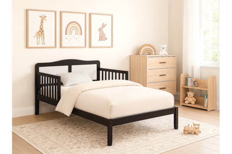 neutral colored girls bedroom with a black bed light wood bedroom furniture beige rug and beige artwork
