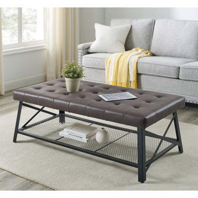 Table basse capitonnée en similicuir avec plateau inférieur en filet et pieds robustes en métal pour plus de durabilité et de style