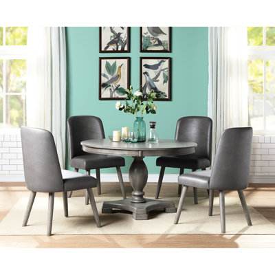Configuration de salle à manger en chêne gris 5 pièces. Table ronde avec piédestal simple. Chaises avec sièges rembourrés et design rétro. Table de 48 po x 30 po. Chaises de l 22 po x l 23 po x H 39 po. Capacité de poids de 100 lb. Capacité de 220 lb
