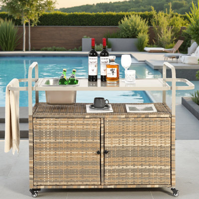 Table de bar d'extérieur avec seau à glace, chariot de patio en osier avec armoire et plateau en acier, chariot de service roulant avec roues verrouillables et panier latéral pour le jardin, la piscine, la cour arrière - beige