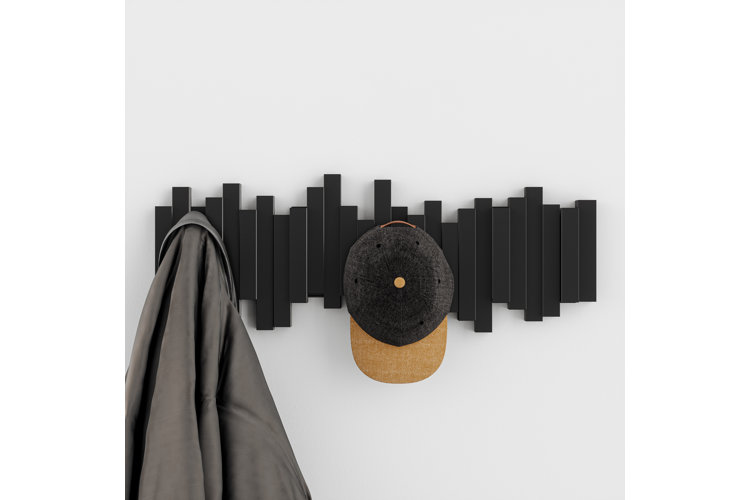 black wall-mounted coat rack with hats hanging from it