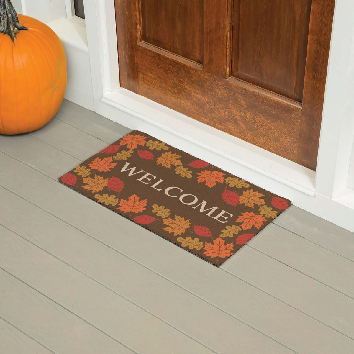 A brown welcome mat with fall leaves