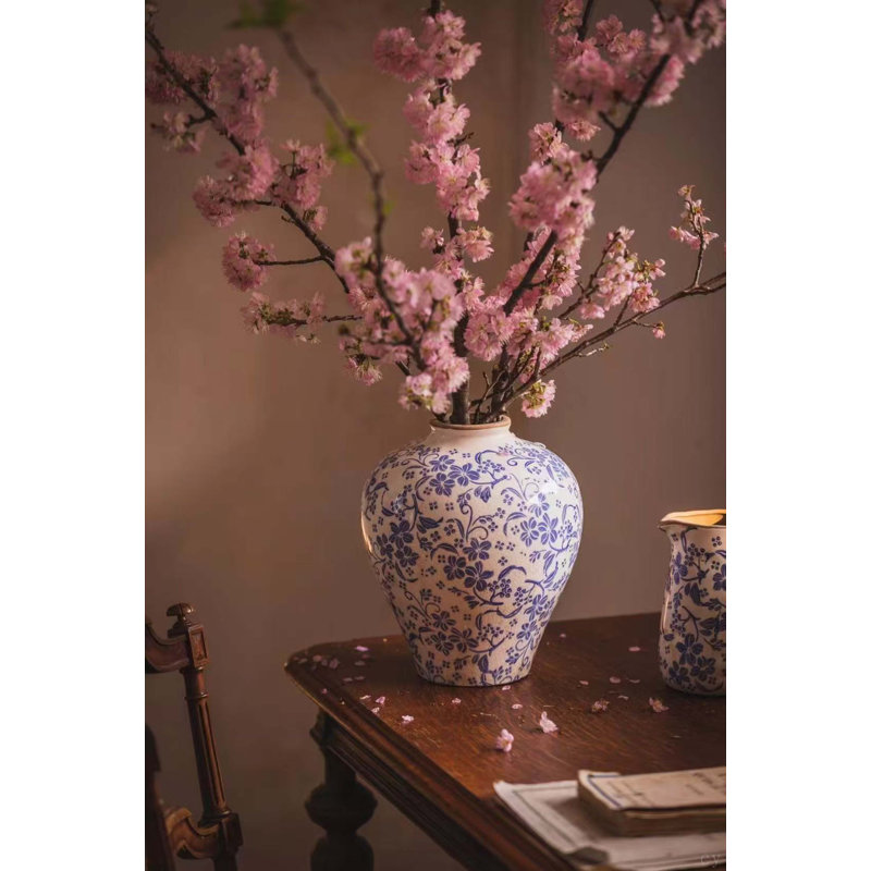 Vase rond en céramique avec finition blanche patinée et motif floral bleu