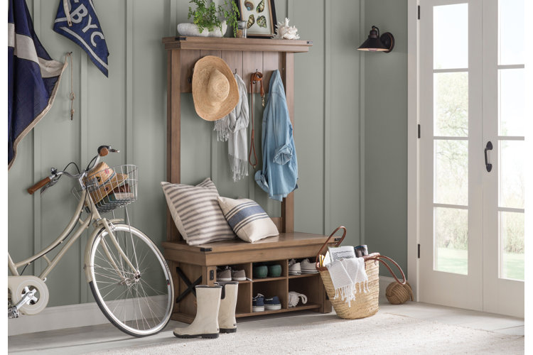 coastal farmhouse entryway will gray-green paneled walls, a farmhouse wall tree, and coastal decor