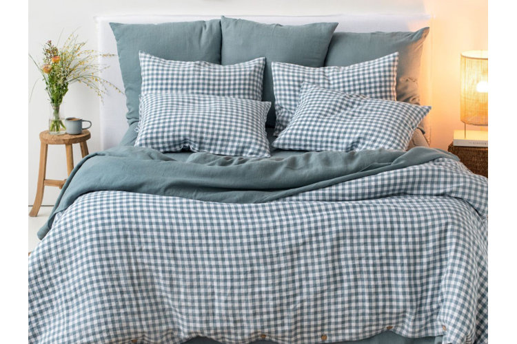 light blue gingham patterned duvet and pillows next to a rustic wood side table