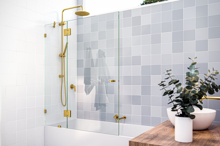 frameless shower door installed in a shower/bathtub combo with brass finish hinges